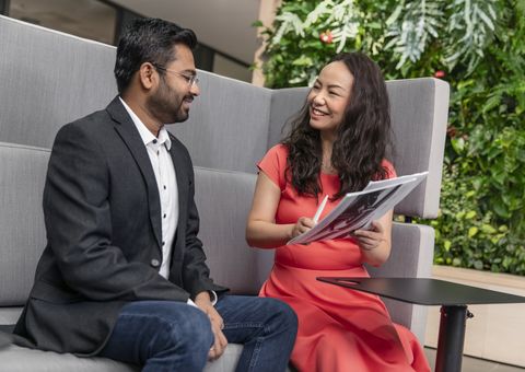 Man and woman chatting in office environment.