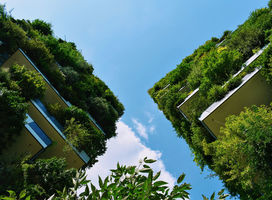 Apartment house with alot of green plants growing on balconies.